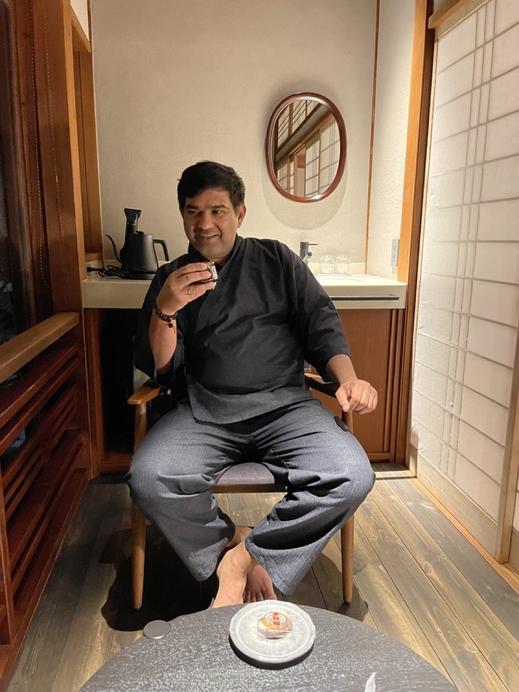 Sitting in a dark yukata with a cup of tea in a ryokan room